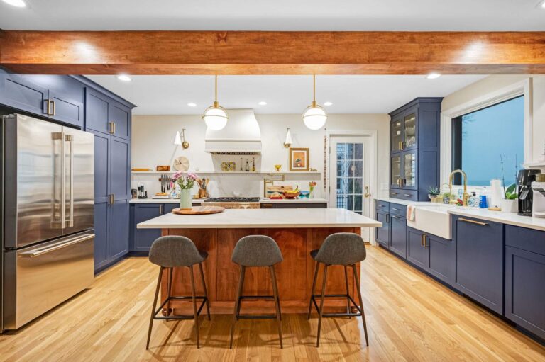 Navy kitchen with a wood beam and island