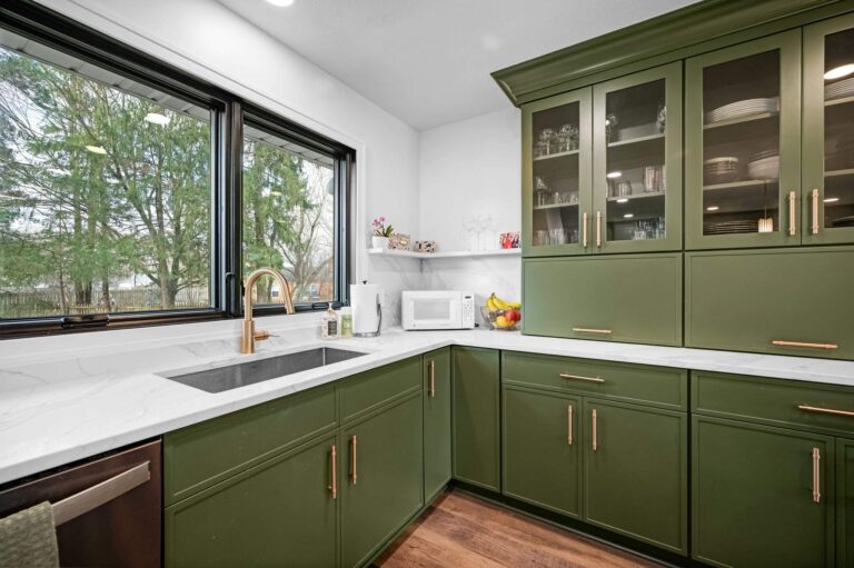 Green kitchen with a stainless steel sink